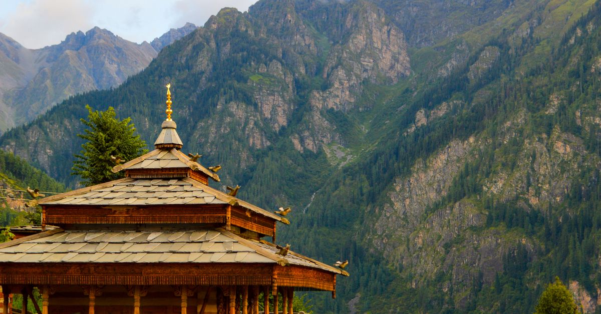 Discover a serene Himachal Pradesh temple set against stunning mountain backdrops, capturing Indian architecture.